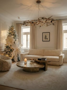 Christmas Season | cosy neutral living room in luxury modern style with Myth brass coffee table, Sofia white sofa, Rose chandelier, rug, christmas tree, candle, and curtain