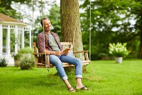 Compo Mann auf Holzschaukel