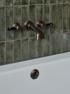 Swadling Invincible Wall Mounted Bath Mixer with Black Levers and Aged Brass finish close-up