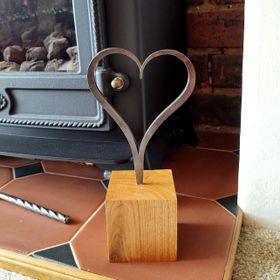 Metal heart, hand made by a blacksmith, set in wood.
