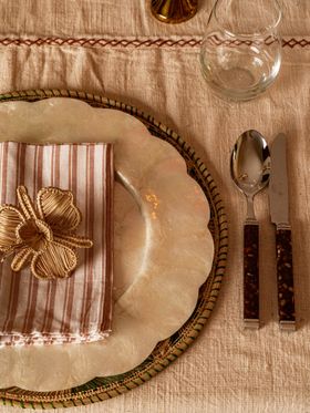 The Roost Latha Placemats £62 For 4, White Scalloped Shell Charger Plate £38, Irrawa Candlesticks £22, Tortoiseshell Cutlery £38