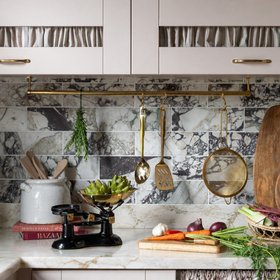 Shaker Style Winter Kitchen With Marble Worktops And Brass Rail
