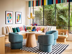 Dwell Terzo Dining Table in Gloss White and Oak, available exclusively at DFS, Dwell Eisha Dining Chair in Blue, available exclusively at DFS, Joules Porthleven Scatter Cushion in Porthleven Stripe Gold, available exclusively at DFS, DFS Kian Velvet Scatt