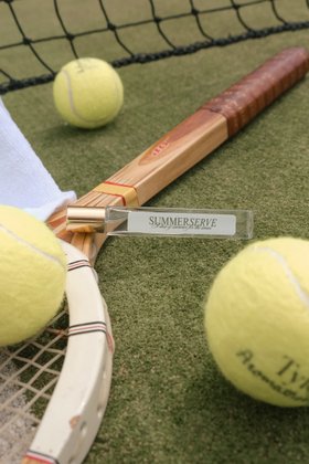 Summerserve Pulse Point Fragrance Placed on Tennis Racket next to Tennis Balls