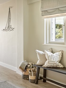 West Wittering-Entrance Welcoming entrance hall in this West Wittering beach house, with a wooden bench, woven storage baskets and layered cushions for a relaxed coastal feelHall