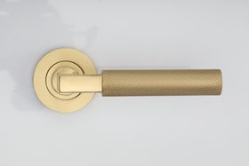 Heritage Brass Phoenix Knurled Door Handle On Round Rose in Satin Brass