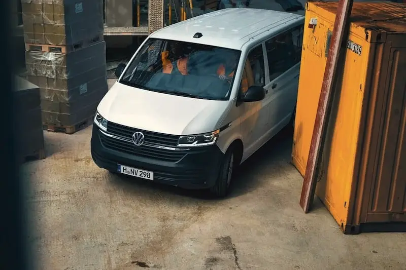 VW Transporter driving through a builders yard