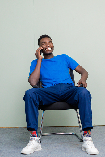 HAPPY MOBILE PHONE CONVERSATION PORTRAITS INDOORS KENYA