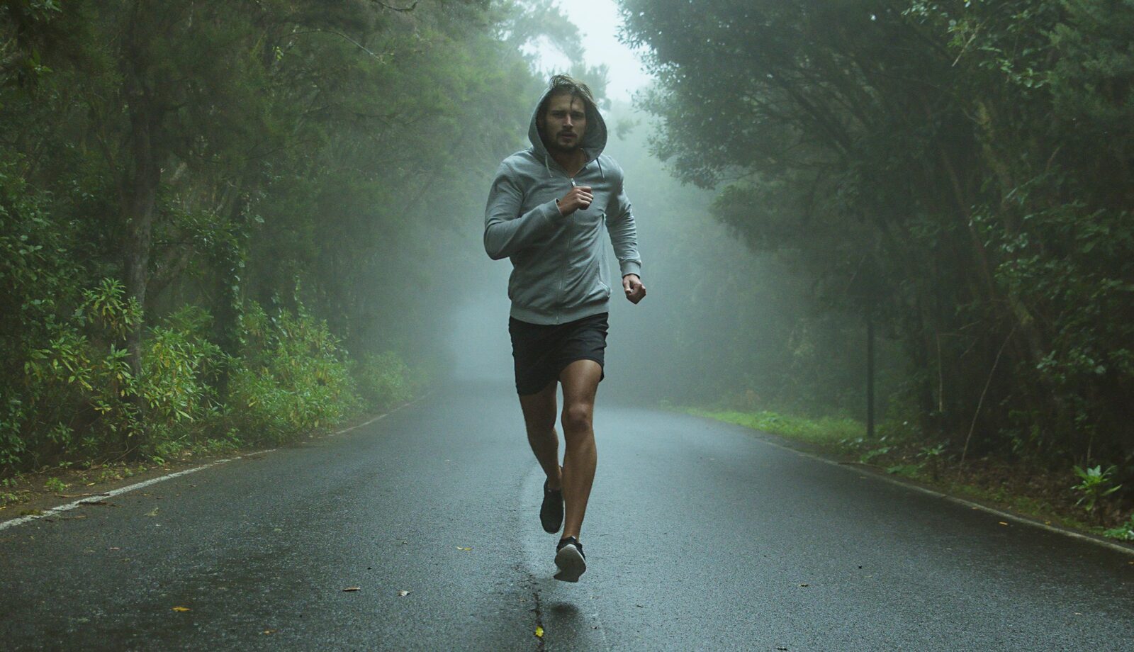 Runner on a foggy forest road