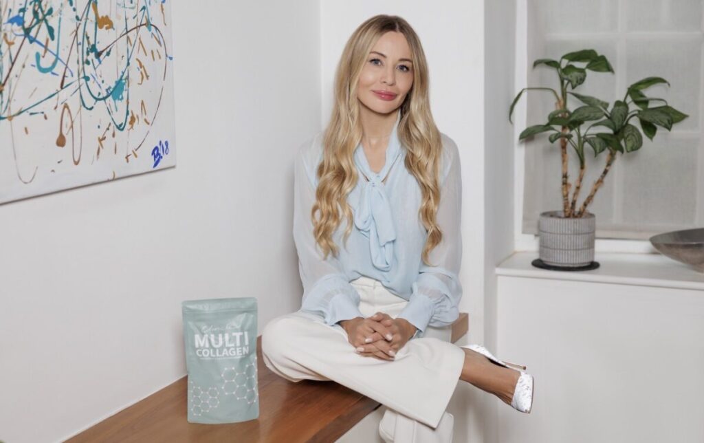 Dr Barbara Kubicka, founder of Clinicbe, seated on a wooden bench holding a bag of medical-grade collagen supplements, representing the shift toward regenerative aesthetics.