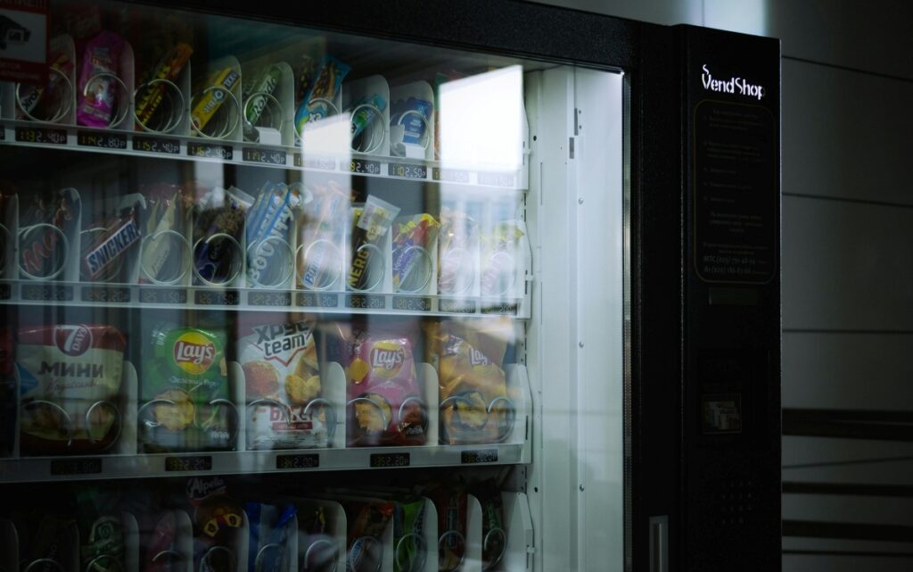 Vending machine stocked with sugary drinks and processed snacks.