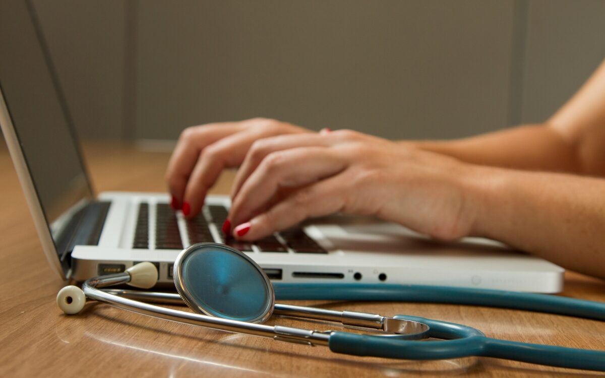 A doctor typing on a PC.