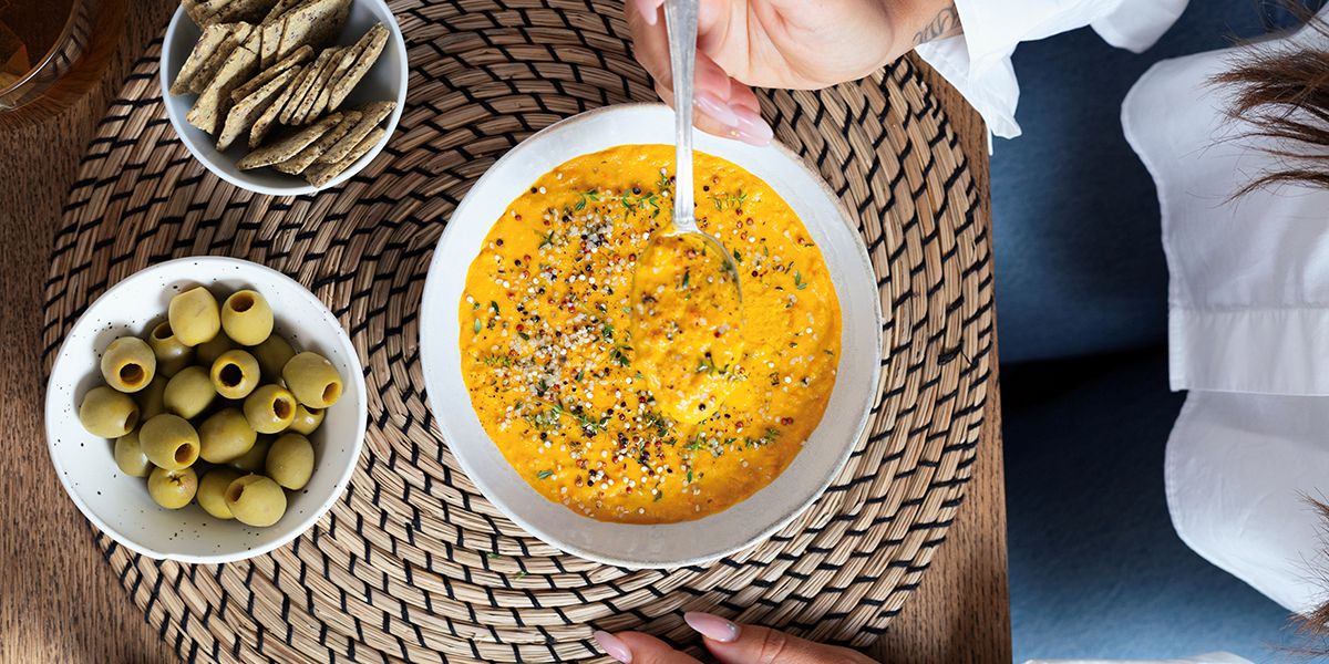 Person eating a healthy bowl of soup with nutritious side dishes supporting metabolic health and autophagy.
