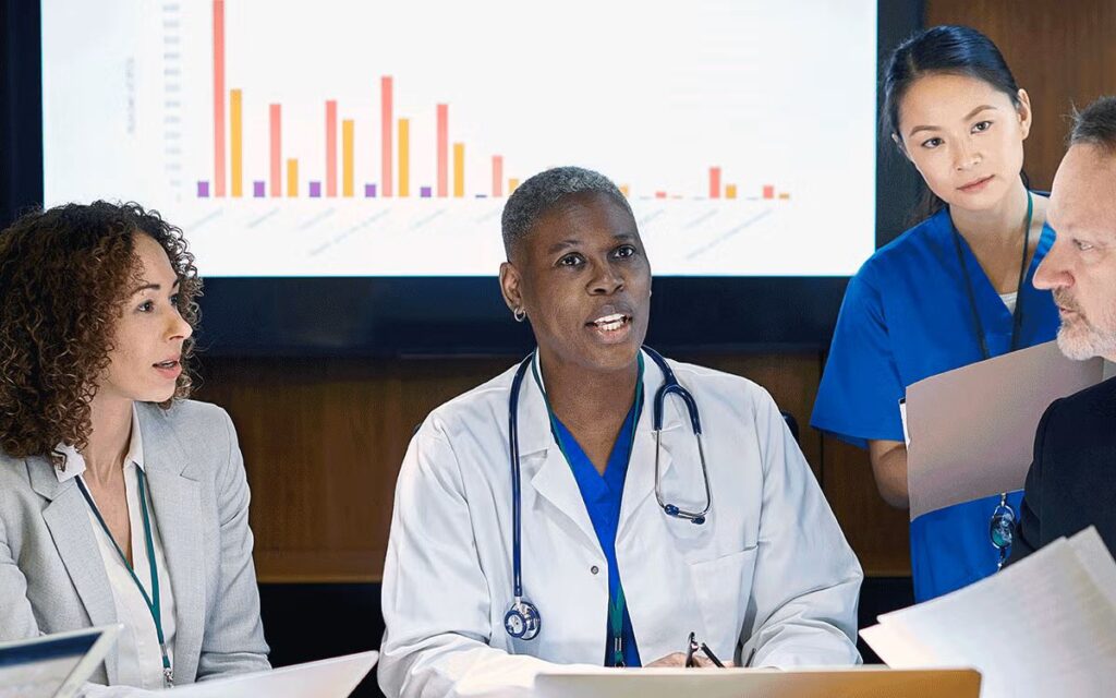 Biopharma team discussing late entry biopharma strategy around a boardroom table with clinical data on screen.