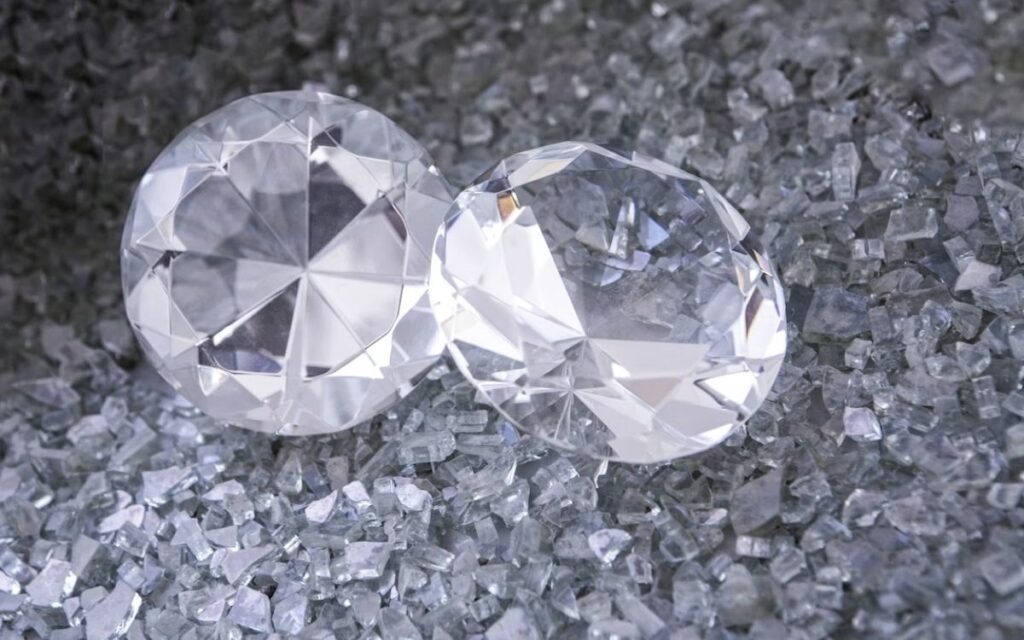 Natural diamonds in healthcare research resting on crushed glass surface.