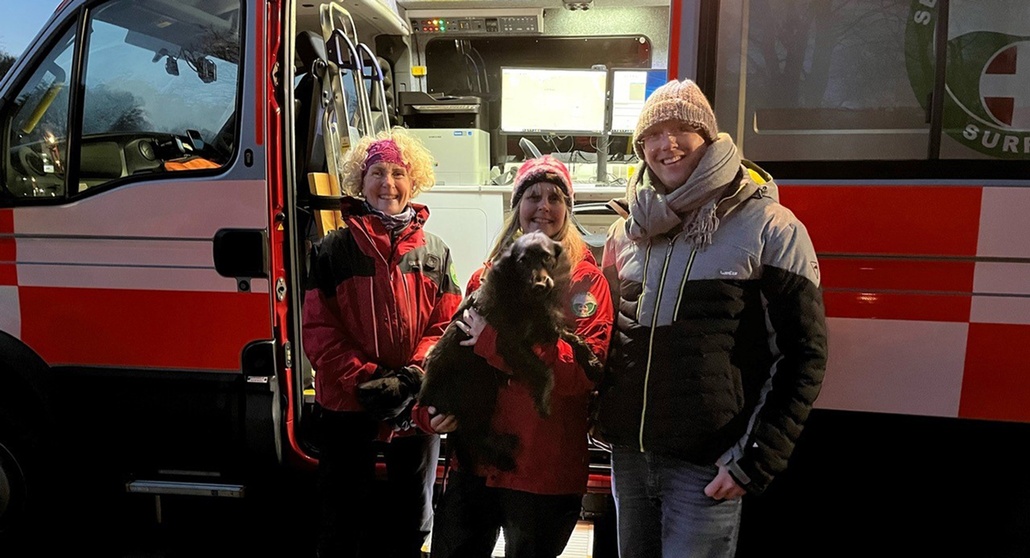 A group of volunteers standing by an emergency vehicle