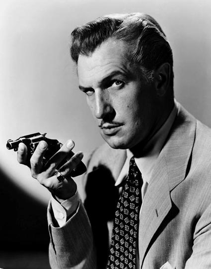 A black and white photo of Vincent Price, the same expression I used for my design but here you can see he's wearing a suit and tie, and holding a tiny handgun in his open right hand like he's doing a soliloquy over it