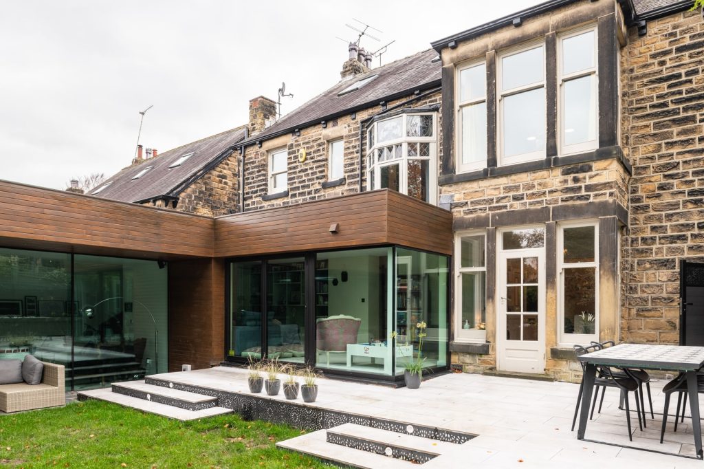 Exterior of large stone villa with modern extension, used as a multi backdrop filming location.