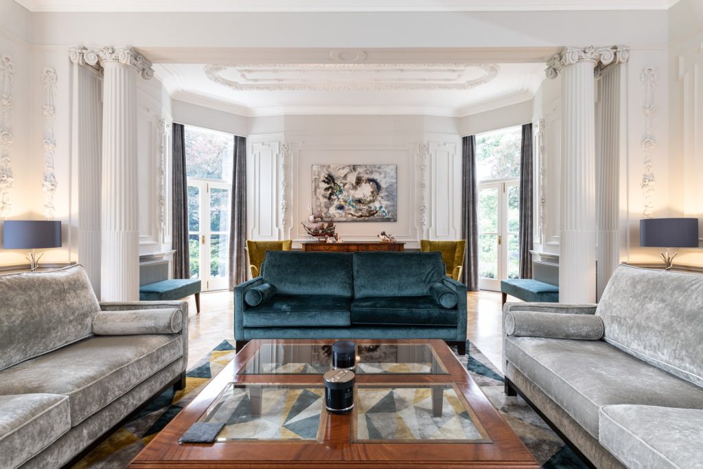 Large living room with velvet sofas inside a stone villa used as a multi backdrop location.