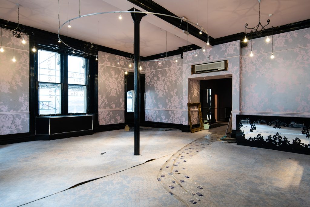 Unused commercial space with period features and patterned wallpaper, now used as a multibackdrop location.