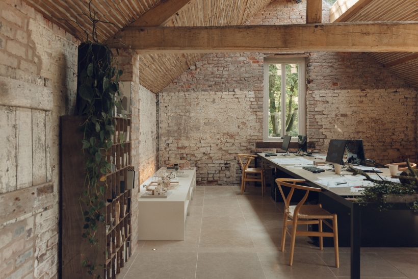 Dining room with exposed brick walls and wooden beams, in keeping with 2025's 'textured' interior trend