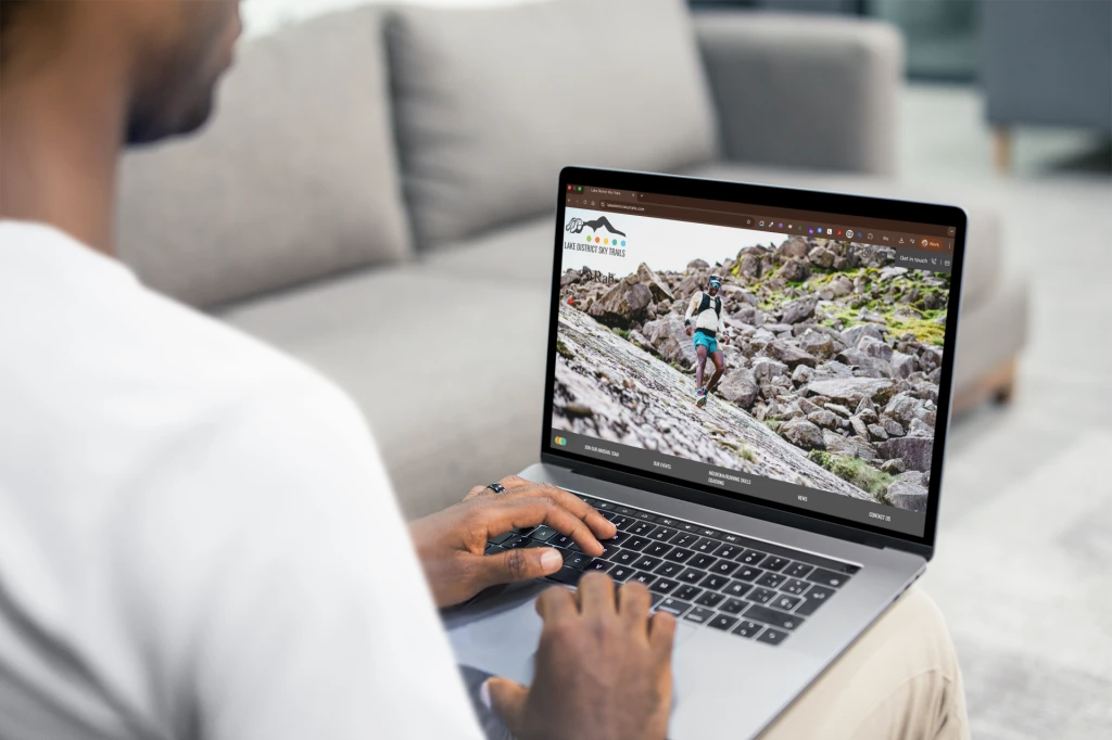 Over the shoulder shot mockup macbook used by a man sitting on a couch a20536