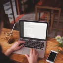 Over the shoulder shot of a woman working with a macbook pro mockup a19525