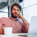 Man looking shocked while looking at a laptop while in an office