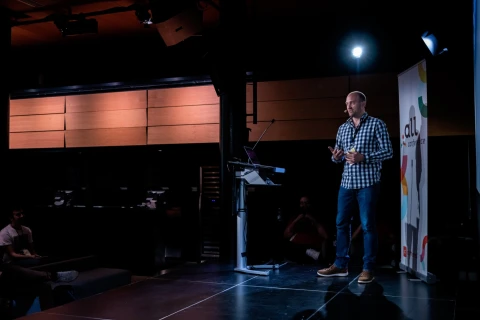 Andrew Armitage talking on stage at the Dot All Conference in Montreal