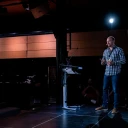 Andrew Armitage talking on stage at the Dot All Conference in Montreal