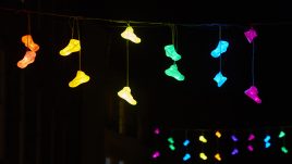 Multicolours shoes hanging in strings across the path