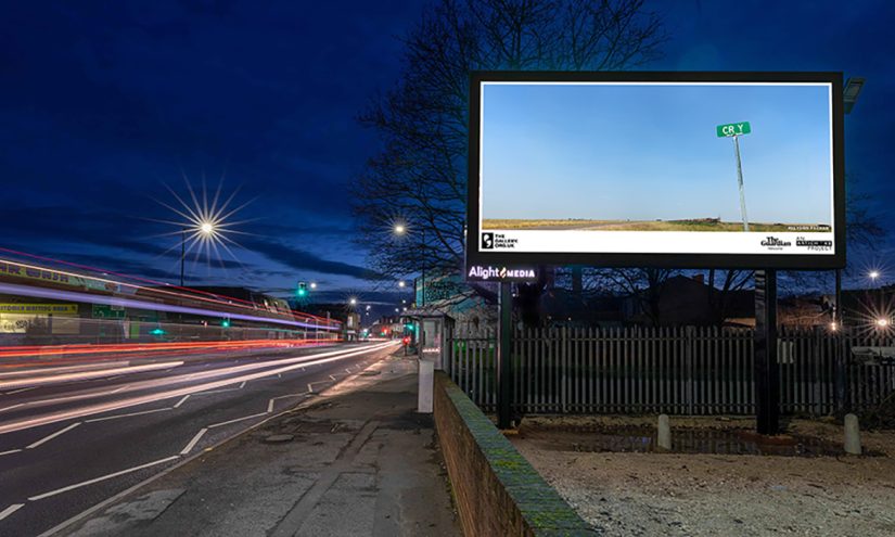 CRY (2022) by Allyson Packer. The Gallery, Season 2, 2023. Produced by Artichoke. Photo mock up by Alight Media A billboard of CRY (2022) by Allyson Packer overlooking a busy road at night. A barren landscape. A freight train can barely be seen in the distance. A road sign in the foreground reads 'CR Y'.