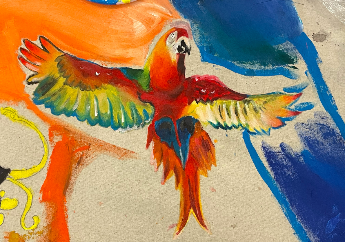 Painting of a colourful Scarlet macaw on canvas material. Its wings are opened wide