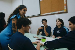 A tutor conversates with students in a classroom