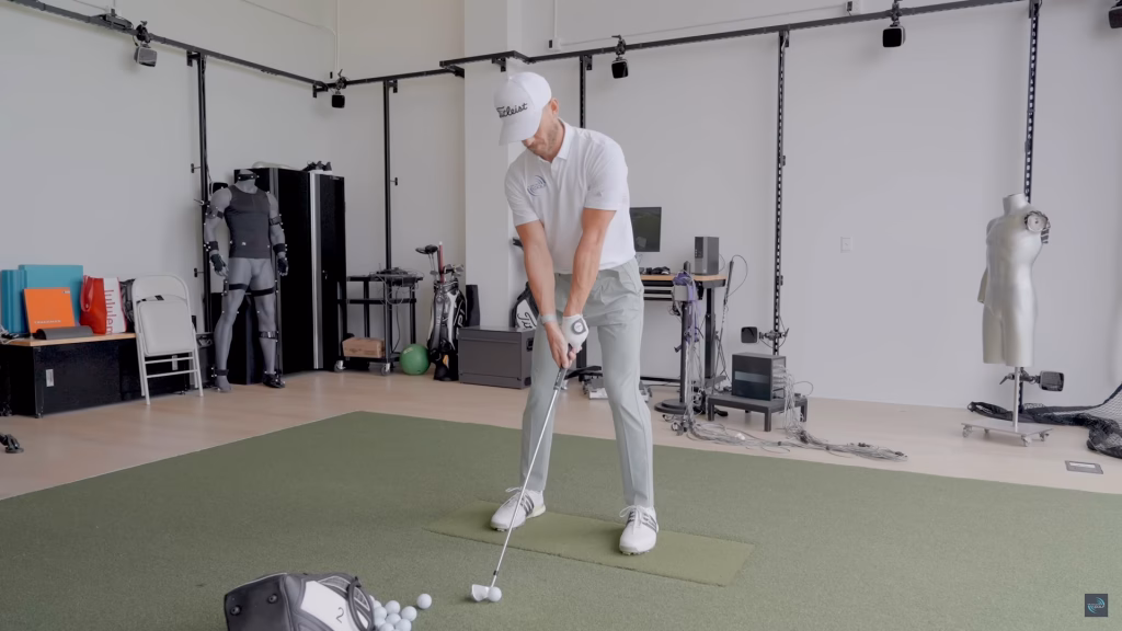 Andy Proudman demonstrating a golf setup position during a TPI screening as part of a Golf Schools session.