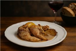 Partridge stew with pears, walnuts, and mushroom broth in a pot.