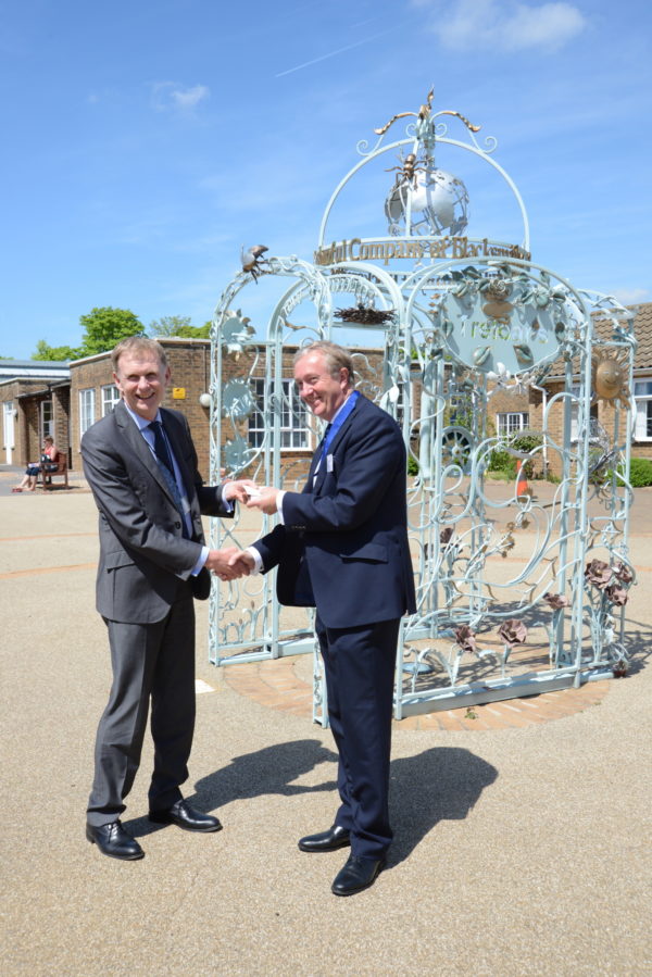 The Master hands the cheque to Principal John Stone