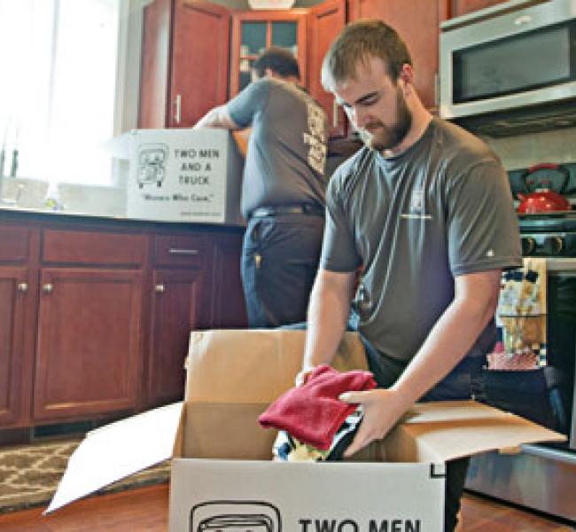 two men and a truck removal employees packing boxes