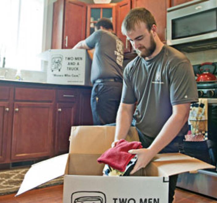 mover packing kitchen items into a box