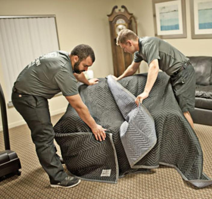 two removal experts wrapping a chair