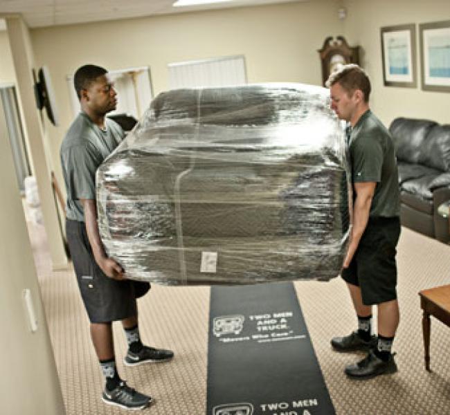 two men and a truck movers lifting furniture
