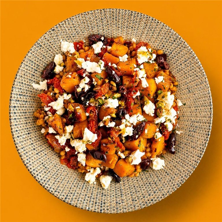 Ensalada de calabaza asada, lentejas, queso feta, asadillo, tomate seco y pistachos