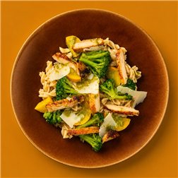 Ensalada de pasta "Cesar" con pollo crujiente, brócoli, verduras y pesto verde