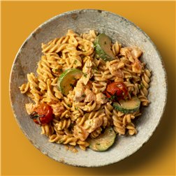 Fusilli integral al pesto rosso con salmón, calabacín y cherrys