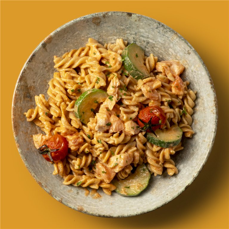 Fusilli integral al pesto rosso con salmón, calabacín y cherrys