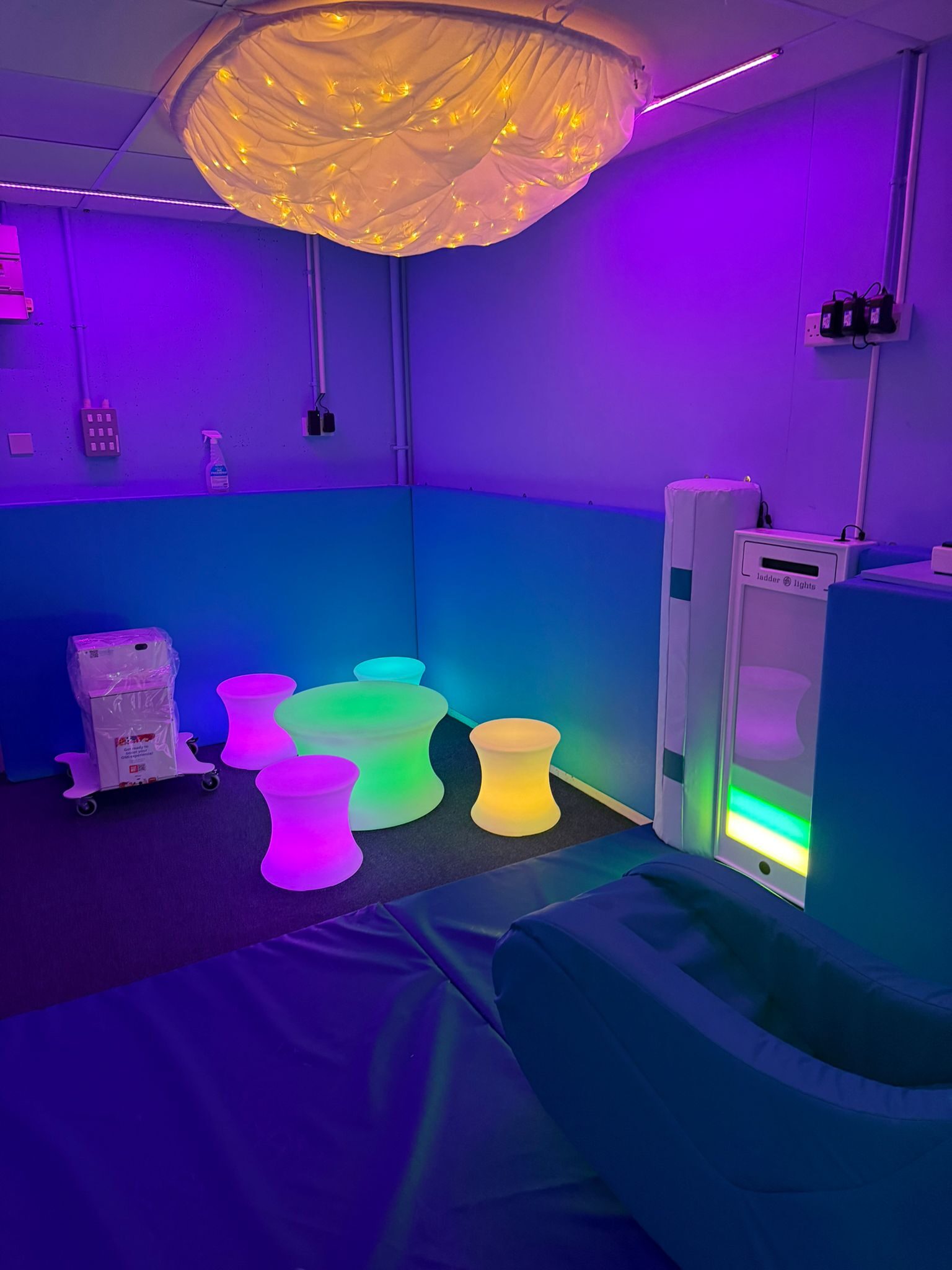 Calm sensory seating area with soft lighting and a ceiling cloud light