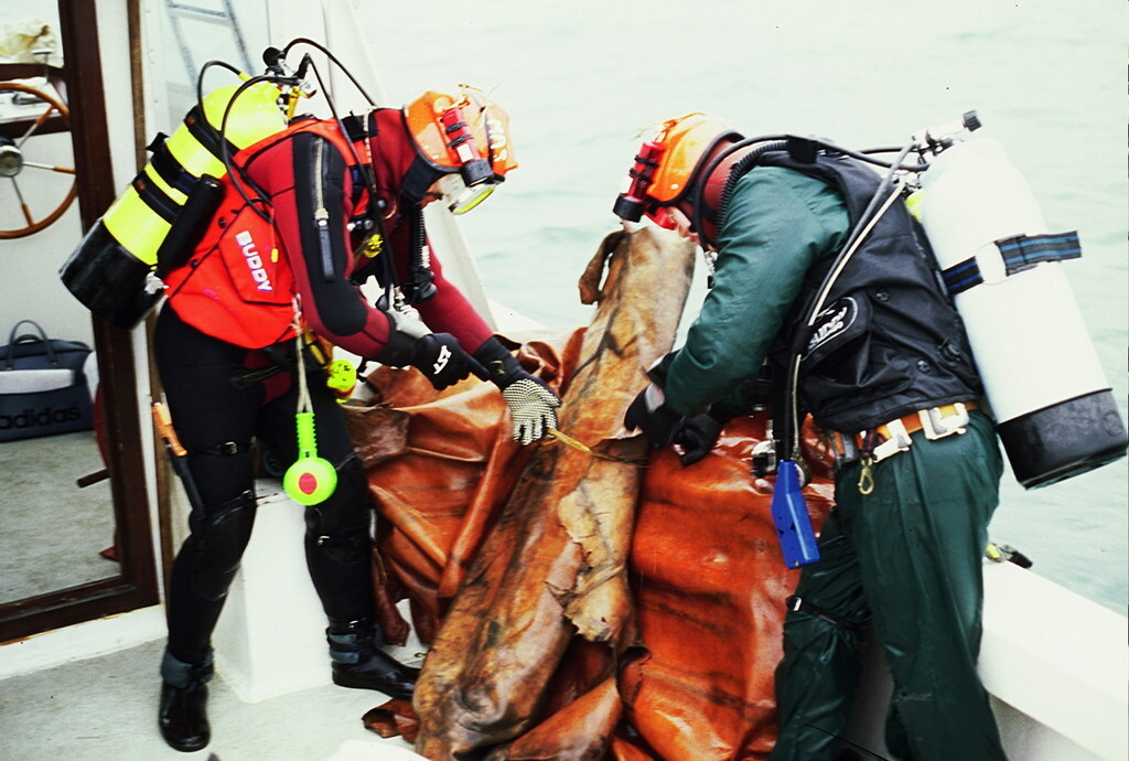 L to R divers John Greep Ian Koch with raised bundles of leather