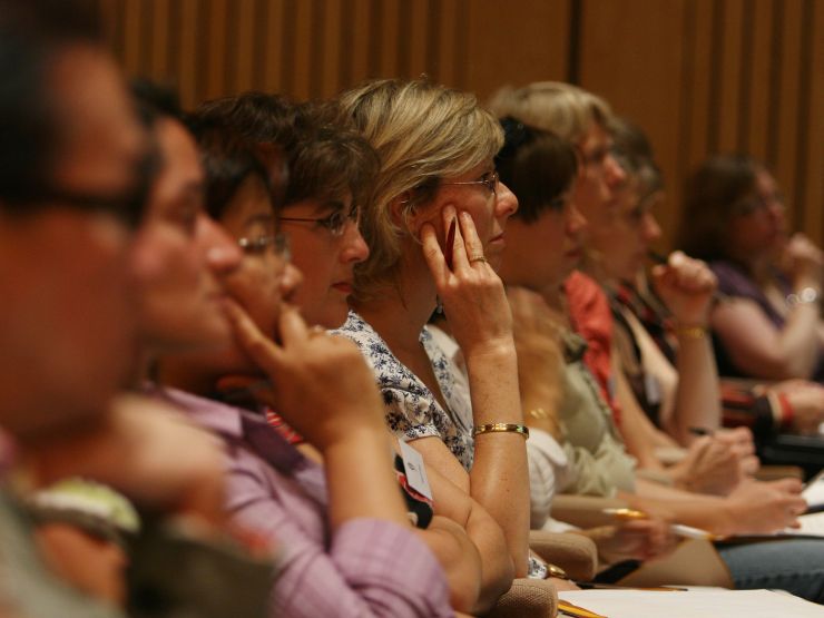 Women sat in an audience looking towards the stage intently