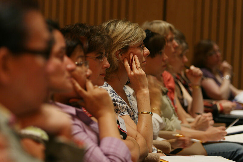 Women sat in an audience looking towards the stage intently