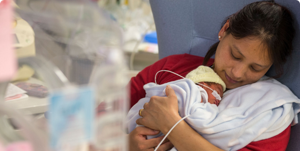 Mother holding her new-born baby in hospital